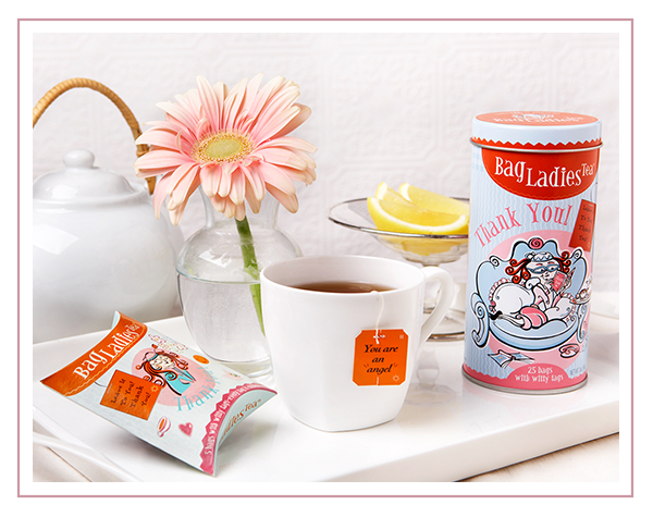 Cozy morning tea tray with Bag Ladies Tea pouch, a steeping cup of tea with tea bag & Bag Ladies Tea Thank You Tea tin.